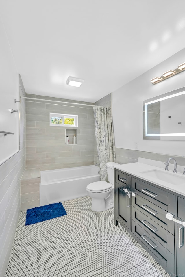 full bathroom with tile walls, toilet, shower / tub combo, tile patterned floors, and vanity