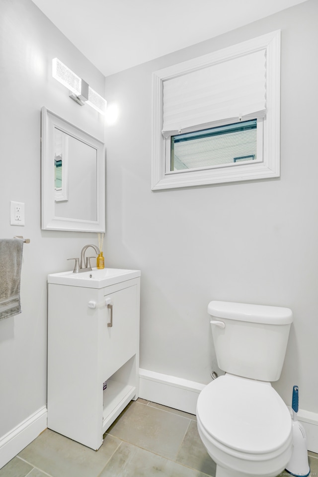 bathroom featuring tile patterned floors, baseboards, toilet, and vanity