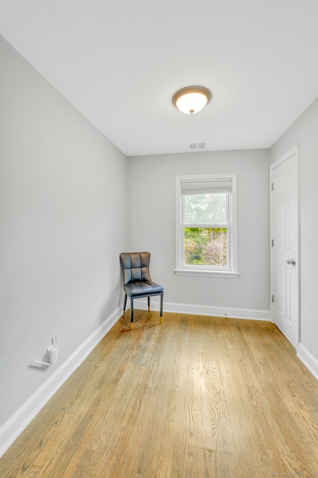 unfurnished room featuring visible vents, light wood-type flooring, and baseboards