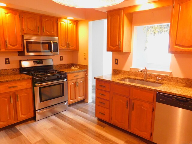 201 Windgate Cir Unit A, Monroe, CT 06468 - kitchen featuring stainless steel appliances, a sink, light wood-type flooring, stone countertops, and brown cabinets