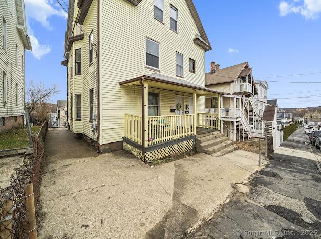 view of front of property with a porch and fence