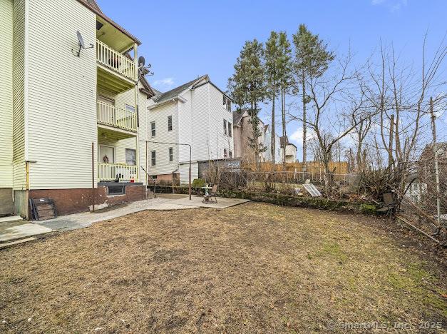 view of yard with a patio, a balcony, and fence