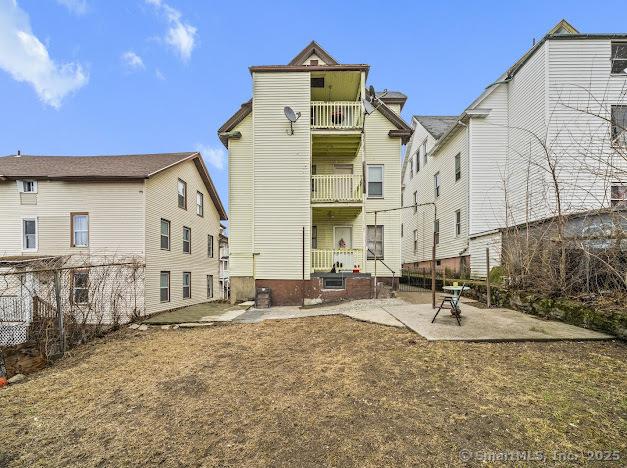 back of house featuring a patio area, a balcony, and fence