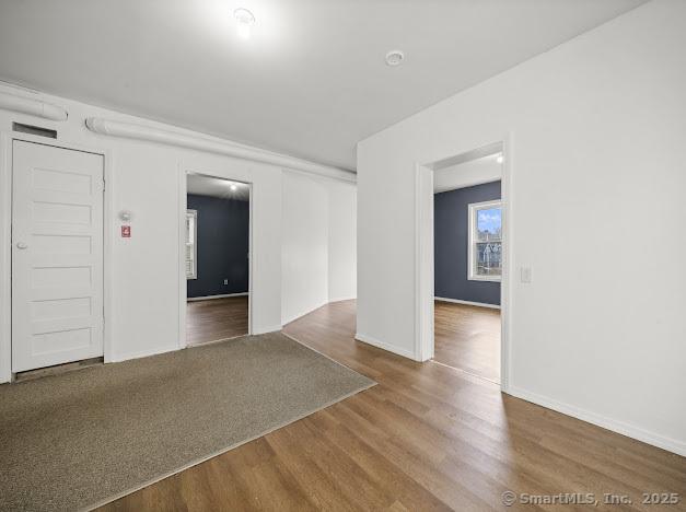 unfurnished room featuring wood finished floors and baseboards