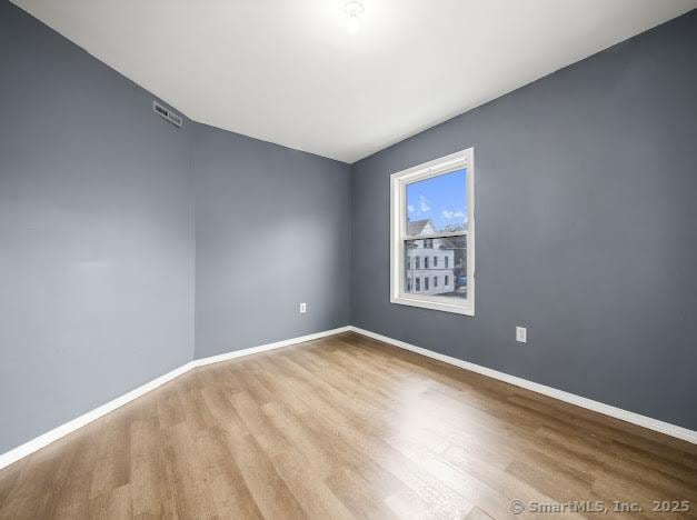 empty room with baseboards and wood finished floors