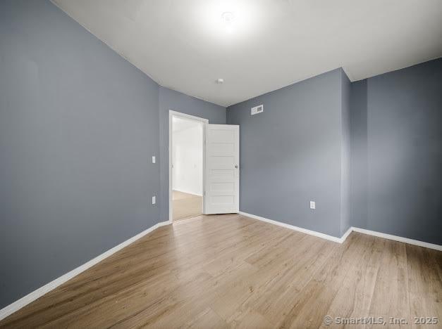 empty room featuring baseboards and wood finished floors