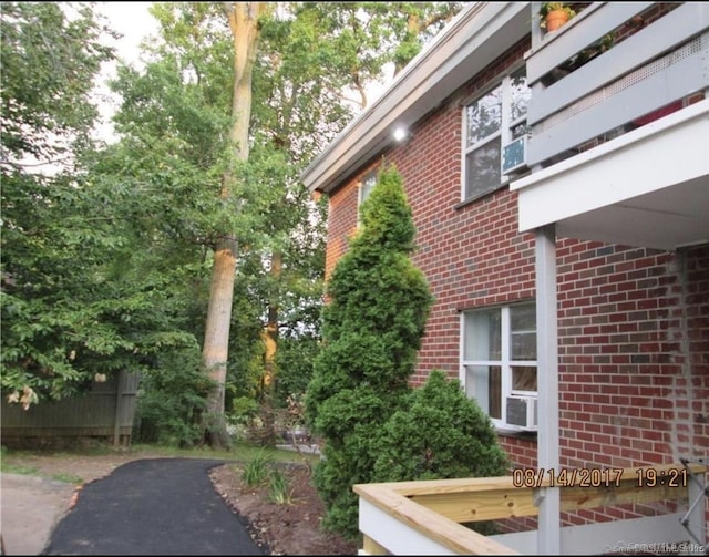 view of side of property with cooling unit and brick siding