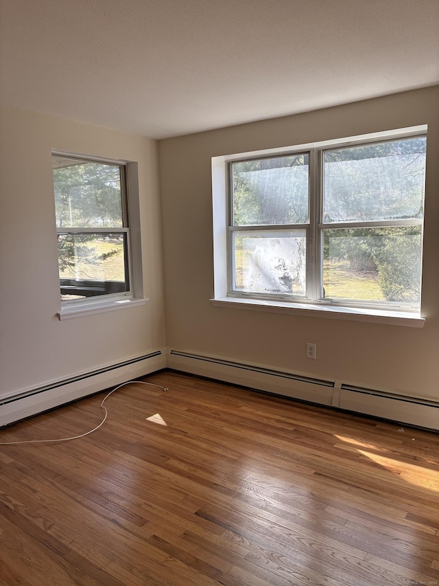 empty room with a wealth of natural light and wood finished floors