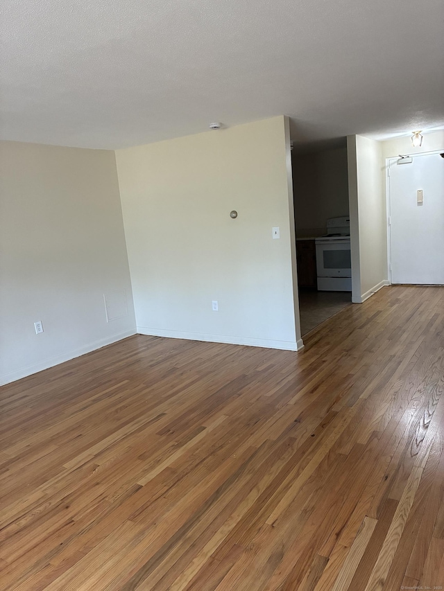 empty room with baseboards and hardwood / wood-style floors