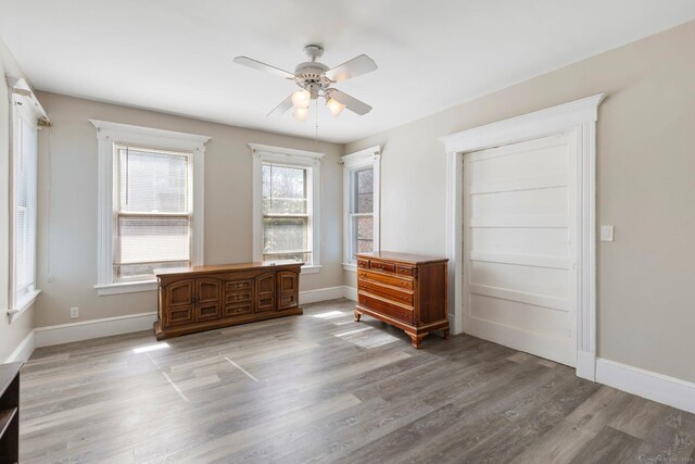 unfurnished bedroom featuring a ceiling fan, baseboards, and wood finished floors