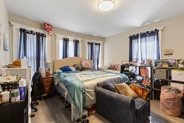 bedroom with multiple windows and wood finished floors