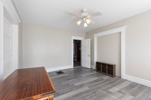 unfurnished bedroom featuring visible vents, baseboards, wood finished floors, and a ceiling fan