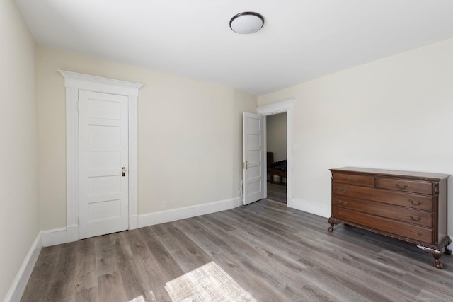 unfurnished bedroom featuring baseboards and wood finished floors