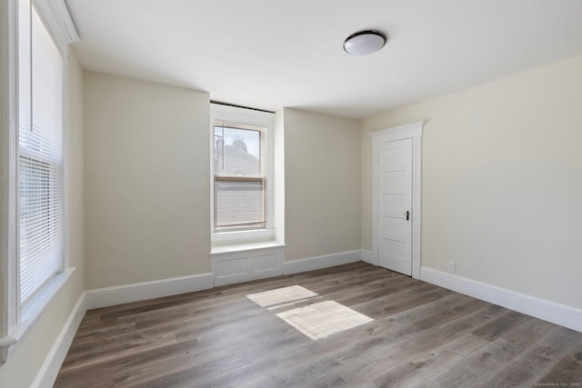 empty room with baseboards and wood finished floors