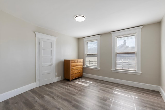 unfurnished bedroom featuring wood finished floors and baseboards