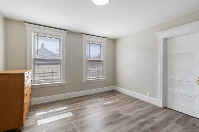unfurnished room featuring baseboards and light wood finished floors