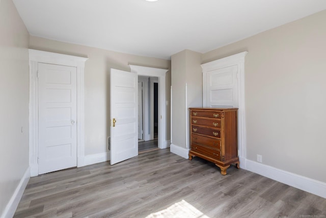 unfurnished bedroom featuring light wood-style flooring and baseboards