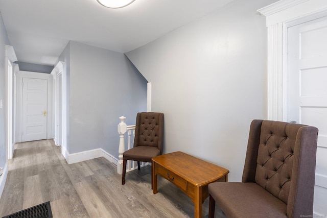 living area with visible vents, light wood-style flooring, and baseboards