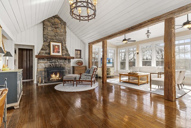 sitting room with ceiling fan with notable chandelier, a fireplace, high vaulted ceiling, and dark wood-style flooring