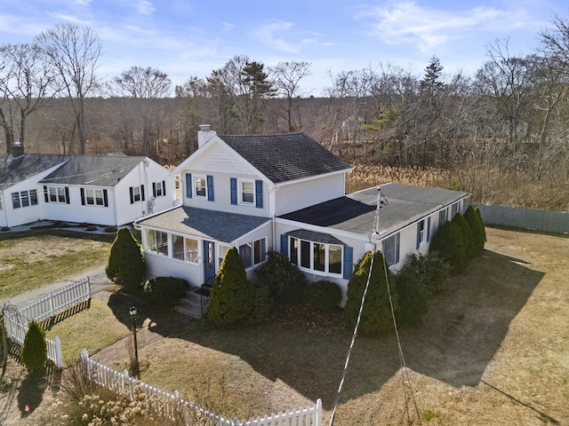exterior space featuring a shingled roof, fence private yard, and a chimney