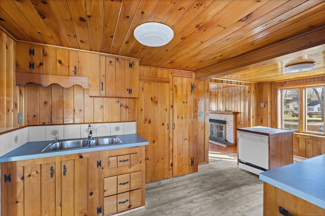 kitchen with light wood-type flooring, wood ceiling, white dishwasher, and a sink