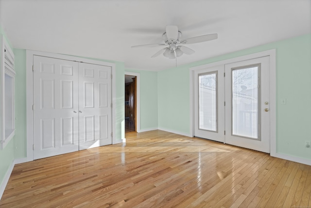 unfurnished bedroom with ceiling fan, baseboards, light wood-style flooring, and access to outside