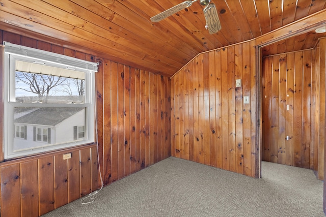 unfurnished room featuring wooden walls, carpet, ceiling fan, vaulted ceiling, and wooden ceiling