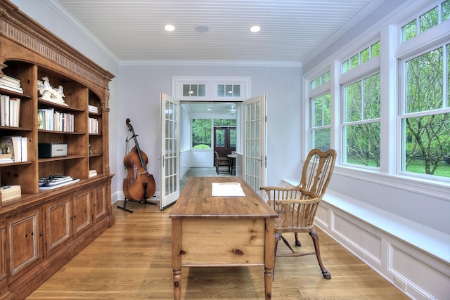 office area with french doors, light wood-style floors, crown molding, and wainscoting