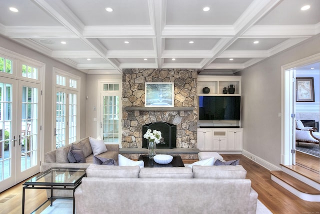 living room with a stone fireplace, wood finished floors, recessed lighting, french doors, and baseboards