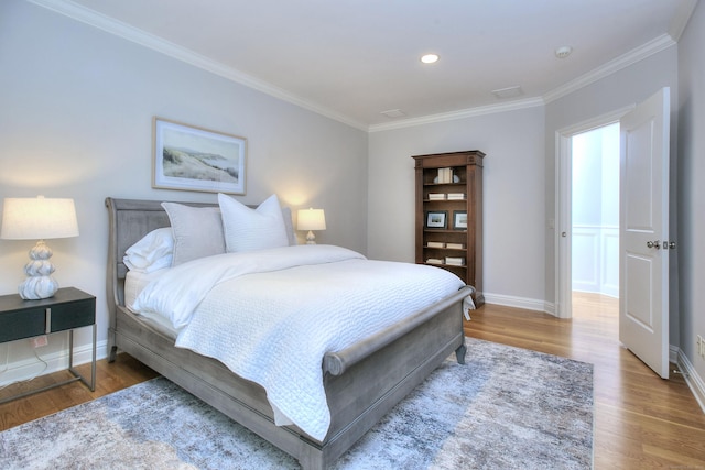 bedroom featuring wood finished floors, ornamental molding, baseboards, and recessed lighting