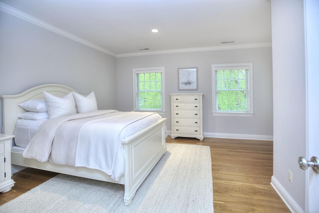 bedroom with crown molding, light wood finished floors, baseboards, and recessed lighting