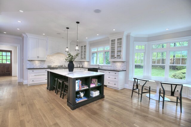 kitchen featuring open shelves, a kitchen island, white cabinets, healthy amount of natural light, and crown molding
