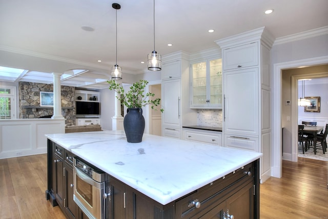 kitchen featuring ornate columns, light wood-style floors, dark brown cabinetry, white cabinetry, and recessed lighting