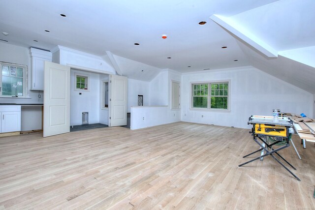 additional living space with lofted ceiling and light wood-style flooring