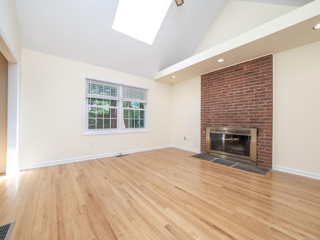 19 Prospect Rdg Apt 16, Ridgefield, CT 06877 - unfurnished living room featuring wood finished floors, a brick fireplace, a skylight, high vaulted ceiling, and recessed lighting