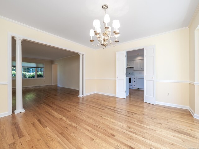 19 Prospect Rdg Apt 16, Ridgefield, CT 06877 - empty room with a chandelier, light wood-style floors, crown molding, and ornate columns