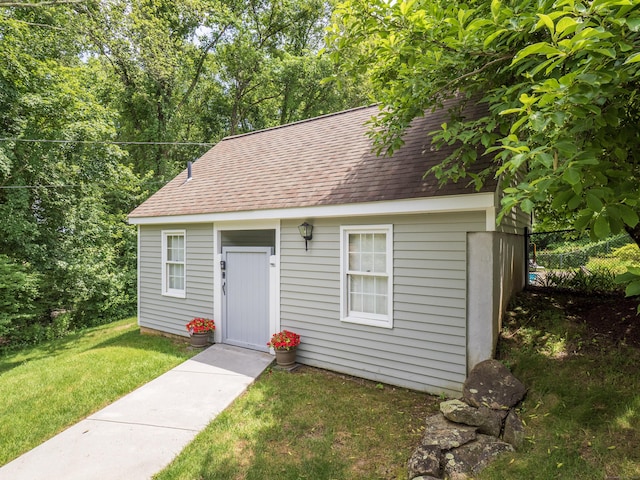 19 Prospect Rdg Apt 16, Ridgefield, CT 06877 - view of front facade featuring a shingled roof, a front yard, and an outbuilding