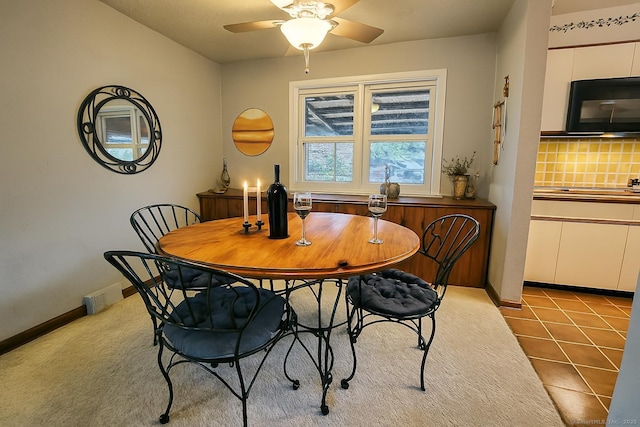 tiled dining space featuring a ceiling fan, visible vents, and baseboards