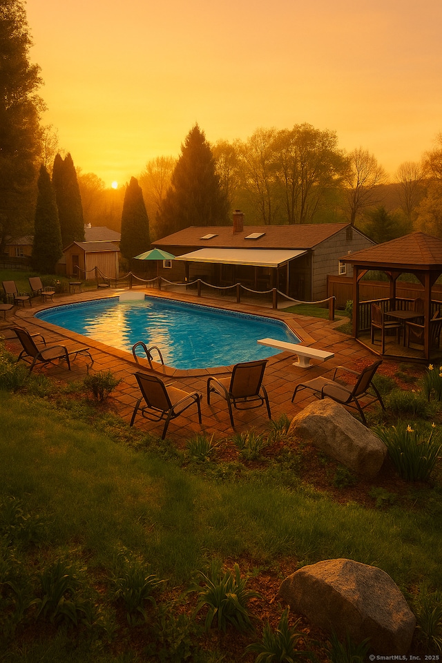 pool with a patio, fence, and a gazebo