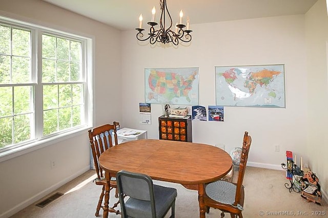 dining space featuring a chandelier, visible vents, light colored carpet, and baseboards