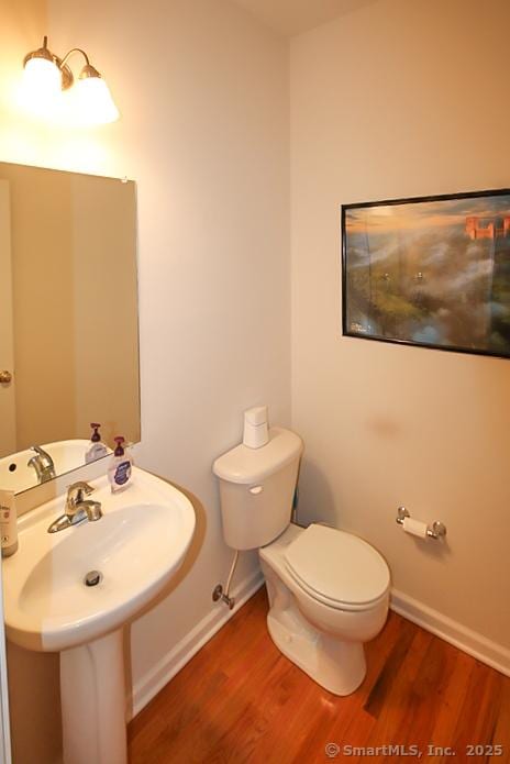 bathroom featuring baseboards, toilet, and wood finished floors