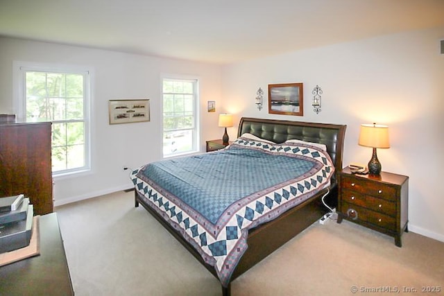carpeted bedroom with visible vents, multiple windows, and baseboards