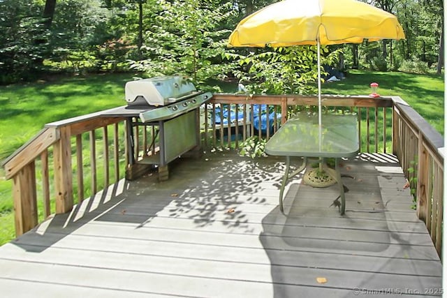 wooden terrace with area for grilling and a lawn