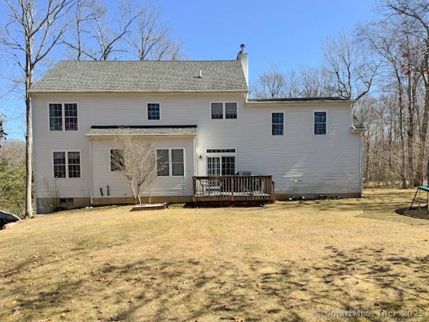 rear view of house with a chimney and a deck