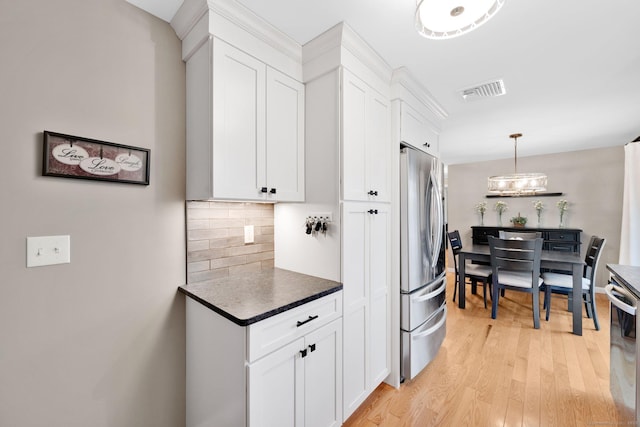 12 Nevins Ave, Enfield, CT 06082 - kitchen with freestanding refrigerator, tasteful backsplash, white cabinets, light wood-style flooring, and dishwashing machine