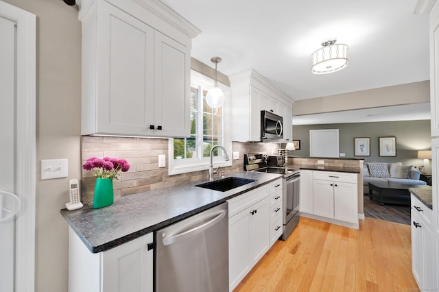 12 Nevins Ave, Enfield, CT 06082 - kitchen with stainless steel appliances, open floor plan, dark countertops, and a peninsula