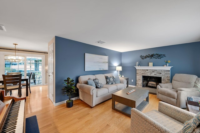 12 Nevins Ave, Enfield, CT 06082 - living room featuring light wood finished floors, a fireplace, and a chandelier