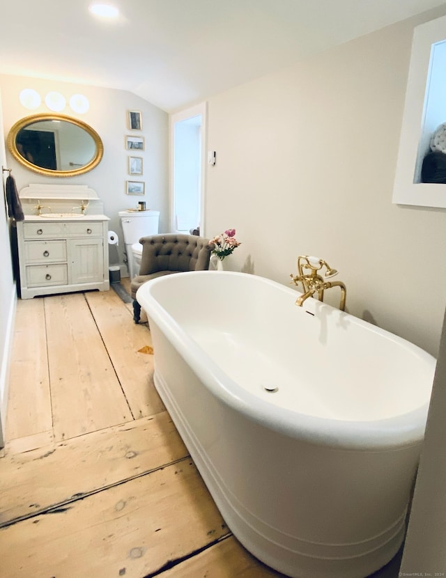 58 Middle Haddam Rd, East Hampton, CT 06456 - full bath with vanity, vaulted ceiling, toilet, a freestanding bath, and wood finished floors