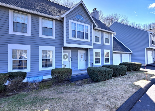 view of front of home featuring a chimney and a garage