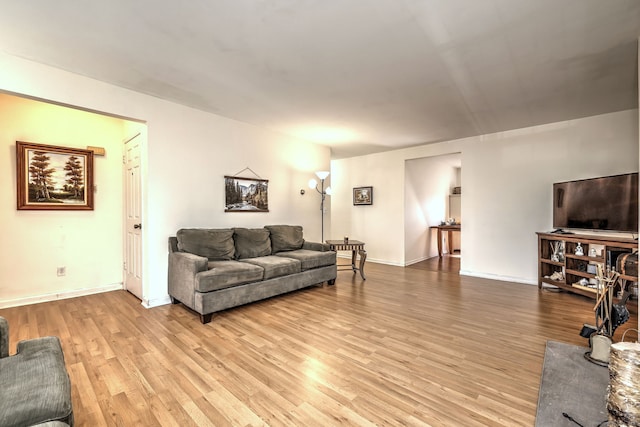 living area featuring baseboards and light wood finished floors